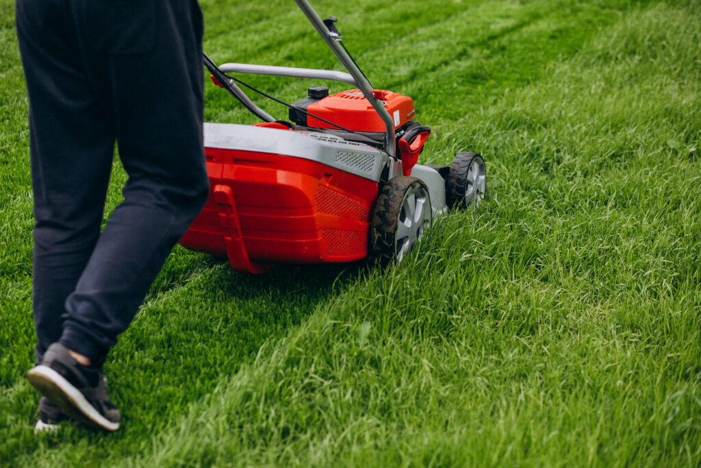 Man cutting grass with lawn mover