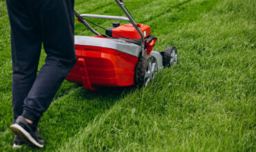 Man cutting grass with lawn mover